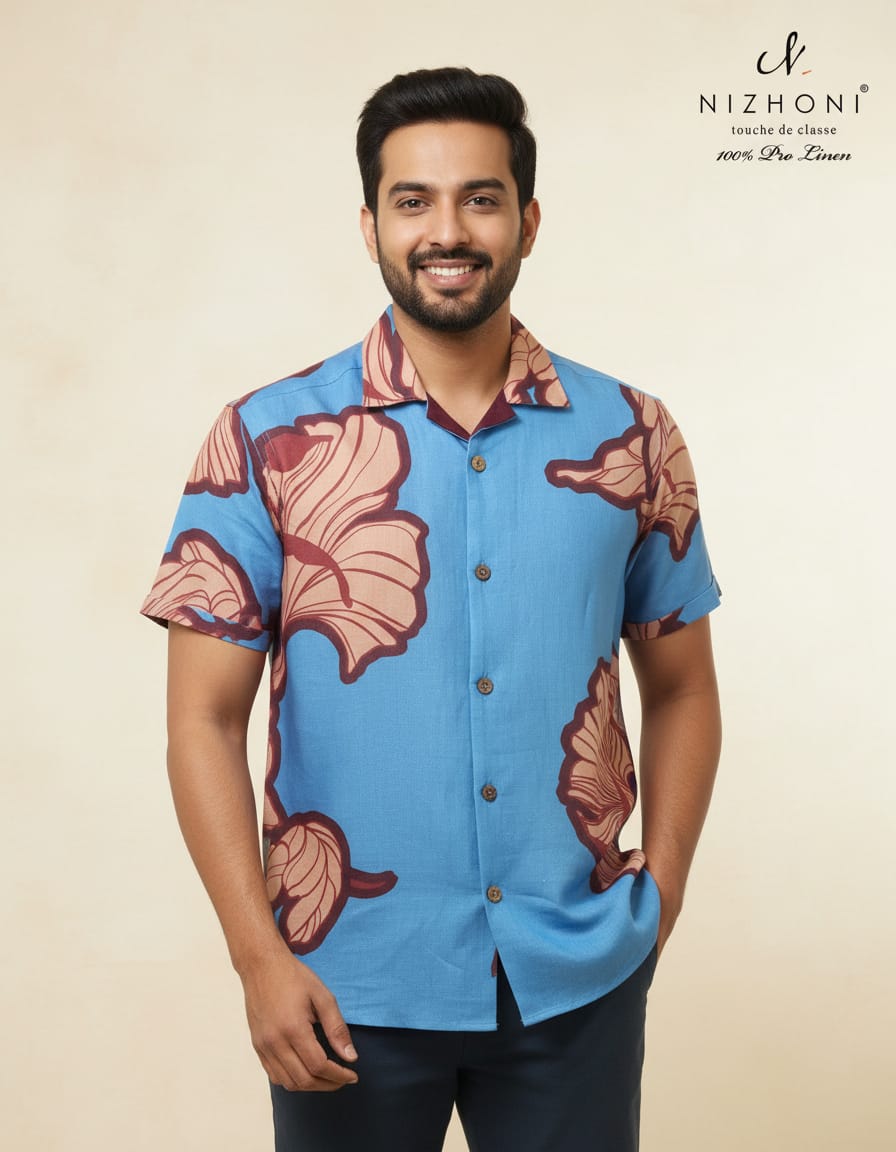 <p>The shirt is a short‑sleeve, Camp collar linen shirt in sky‑blue with a large pink‑beige floral (hibiscus‑style) print outlined in maroon. It has a classic collar, brown wooden buttons.&nbsp; The fabric is 100% Pro Linen from the brand Nizhoni, marketed as “touche de classe” (a touch of class).<br></p>